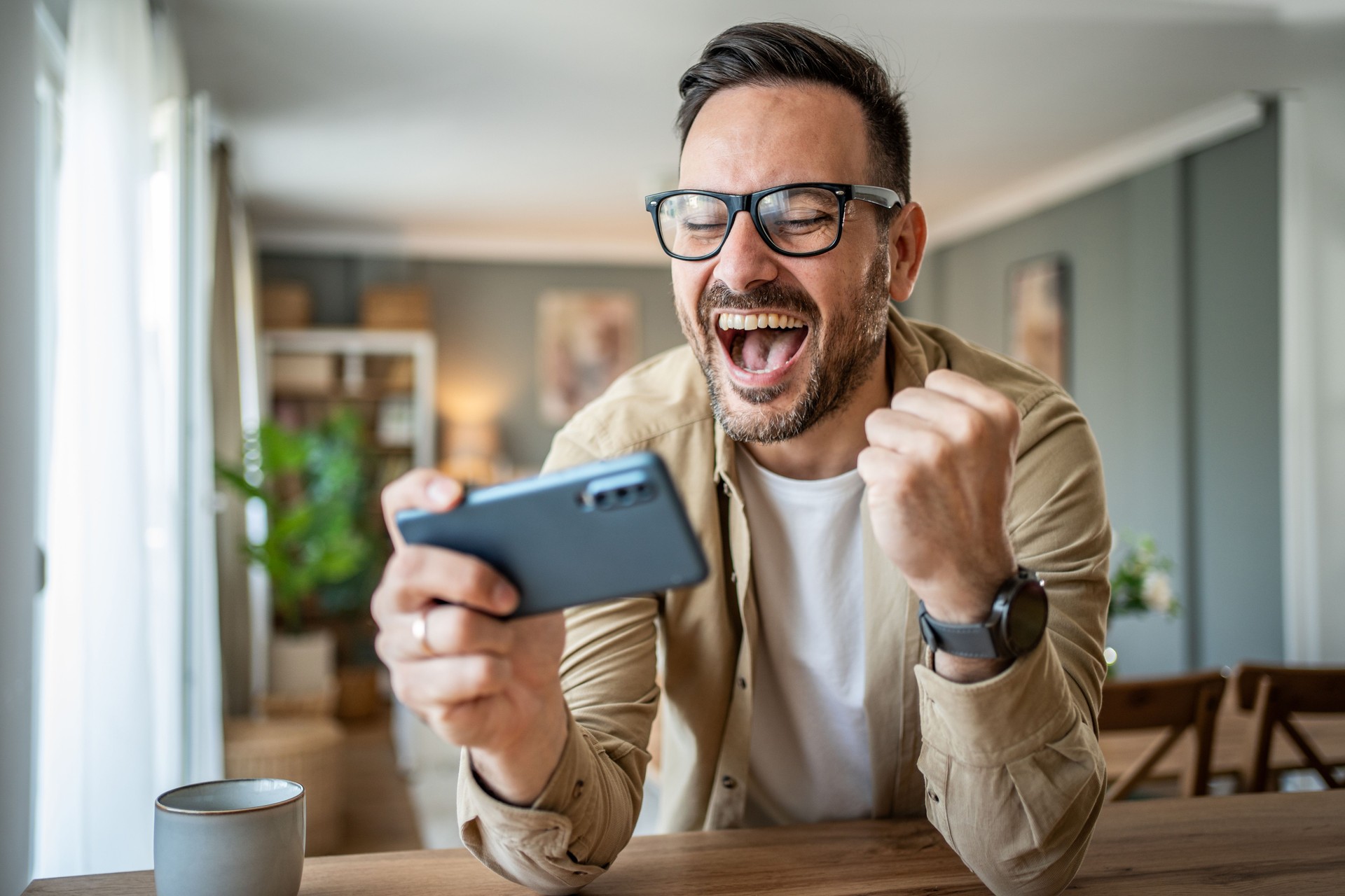 Excitement in the palm of your hand - Young man track sports results through a mobile betting application